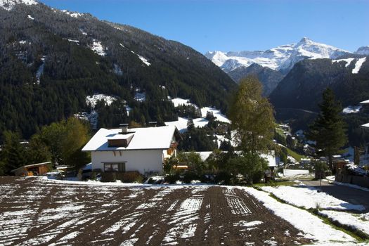 Snowy mountain, village and trees in Alp region of Austria