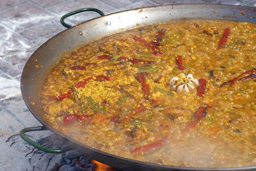 Traditional cooking of a paella on an open fire