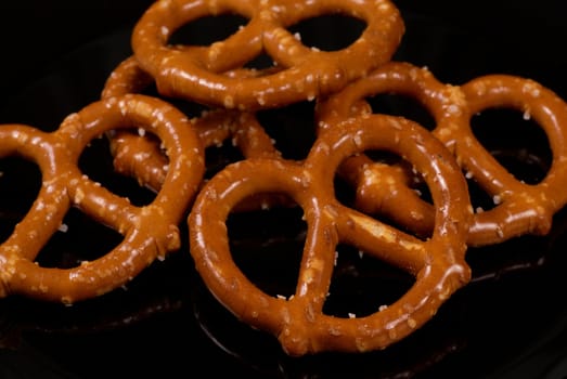 Fresh salted pretzels on a black plate