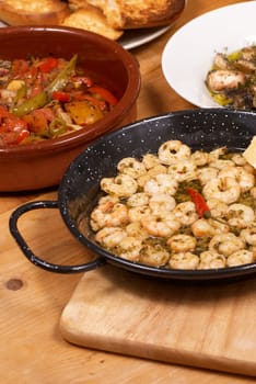 Assortment of several Spanish tapas on a wooden table