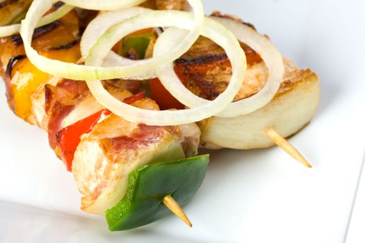 shashlik on a plate with a tomato and salad leaf