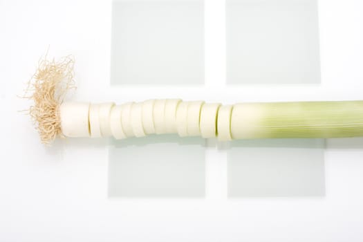 slices of leek on a glass chopping board