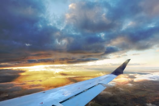 Photograph taken from airplane, moments after the sun gazes through the clouds.