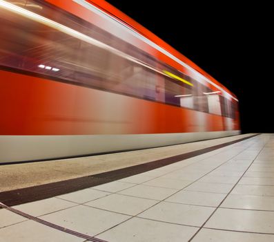 Photograph of a modern train passing by a subway station
