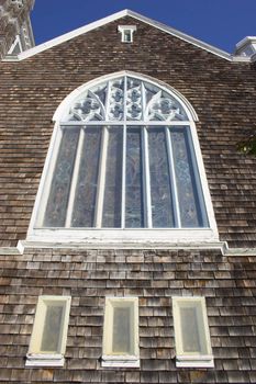 Fragment of historic wooden church with shingled walls and roof  