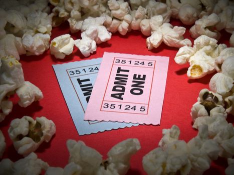 Close up shot of two generic admission tickets surrounded by popcorns.