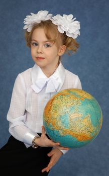 Schoolgirl with a geographic globe in hands