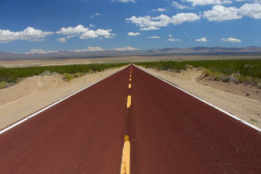 A road runs through the vast openness of the Mojave National Preserve in California.