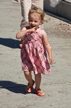 Cute little European toddler girl having fun at the playground in park