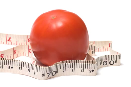 Red tomato and a measuring tape on white background.