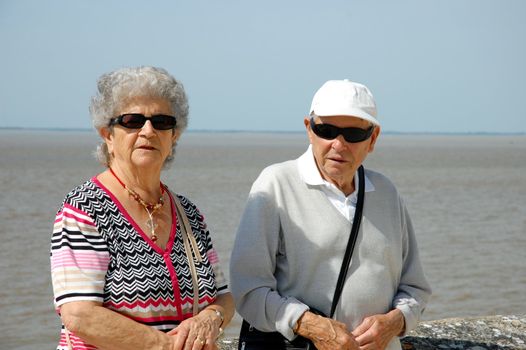 Happy senior couple walking along the coast of Brittany