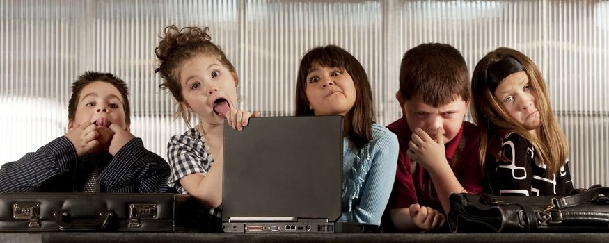 Kids posing as a professional business team making funny faces