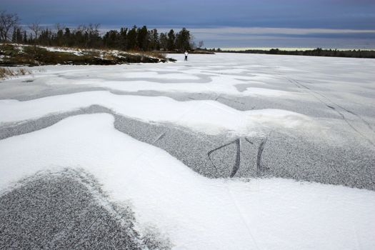 Snowmobile route over frozen lake with colorful reflections of the sun in snow crystals