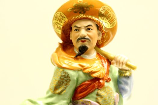 Ceramic Chinese statuette on yellow background