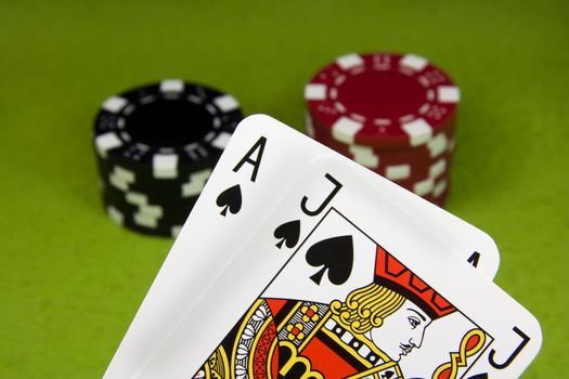 Poker Ace and Jack spade over chips stack