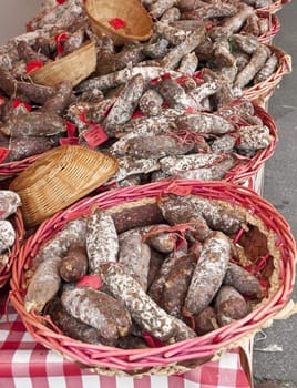 Many french sausages in some osier baskets in a marketplace