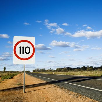 Speed limit kilometer per hour road sign by road in rural Australia.