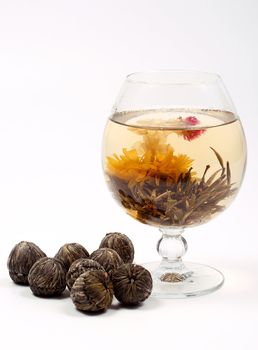Glass with a blooming flower green tea on white background