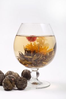 Glass with a blooming flower green tea on white background