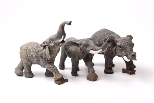 Three ceramic elephant figurines isolated over white background