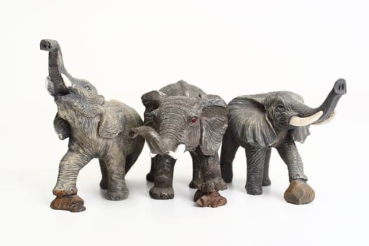 Three ceramic elephant figurines isolated over white background
