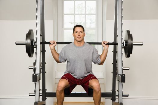 Man lifting weights in gym.