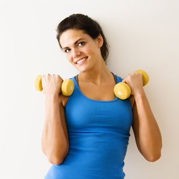 Woman holding hand weights and smiling.