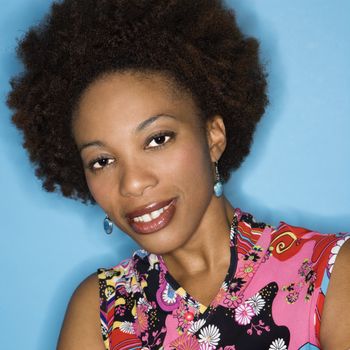 Head and shoulder portrait of woman with afro wearing vintage print fabric.