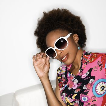 Woman with afro wearing vintage print fabric and oversized sunglasses.