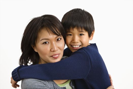 Asian mother and son hugging and smiling.