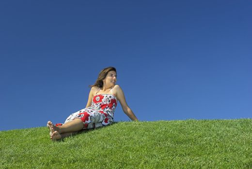 Beautiful woman relaxing on a beautiful green field