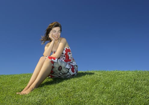 Beautiful woman relaxing on a beautiful green field