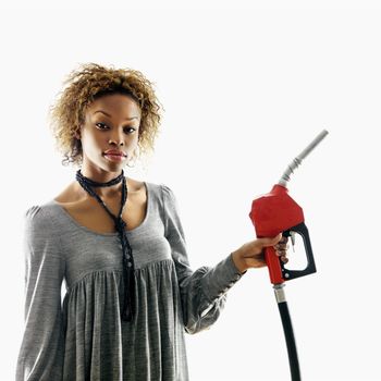 Portrait of pretty young woman holding gas pump nozzle on white background.