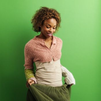 Portrait of pretty young woman standing against green background.