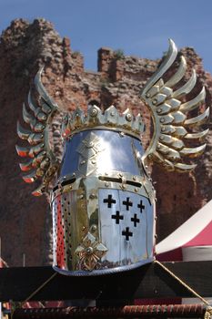 Knightly helmet on a background of ruins of a fortress
