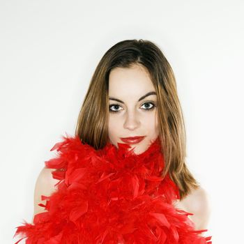 Pretty Caucasian woman with red feather boa around body looking at viewer.