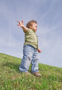 Toddler standing on a hill, view from below
