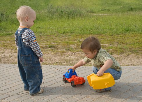 Two boys trying to repair a toy truck