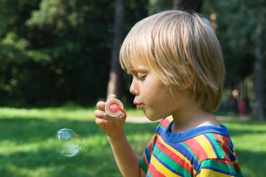 Little boy with soap bubbles, outdoor shot
