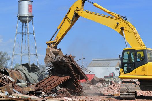 An excavator sorting waste at a building demolition site