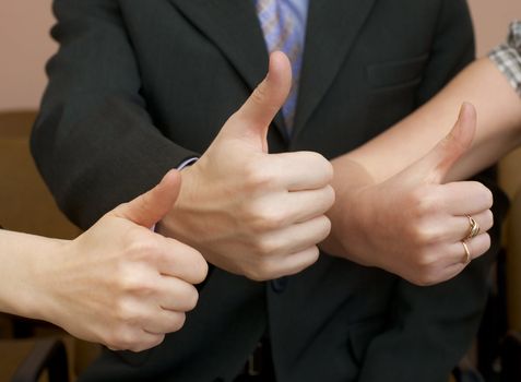 Team of cheerful businessmen show thumb up