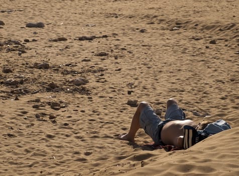 Man relaxing on a beach on the Mediterranean island of Malta
