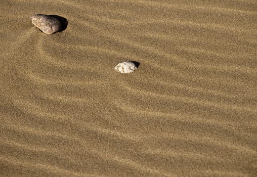 Stones laying on desert or beach sand dunes