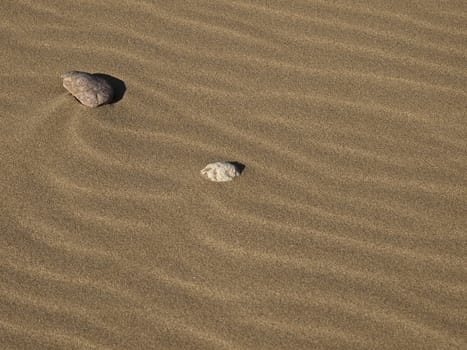 Stones laying on desert or beach sand dunes