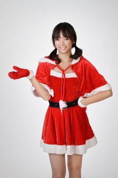 Happy Christmas girl introduce over gray studio background.