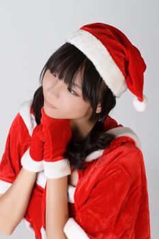 Christmas girl make a wish, closeup portrait over gray studio background.