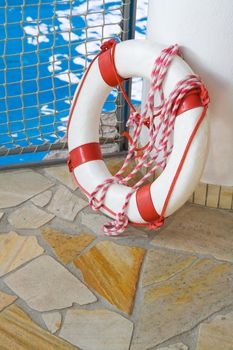 White life buoy on floor by swimming pool