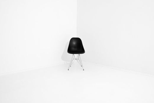 Lonely retro chair in a corner of a white room