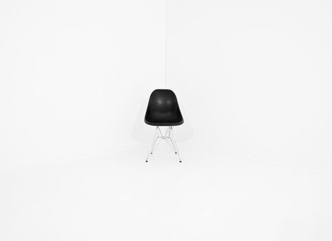 Lonely retro chair in a corner of a white room