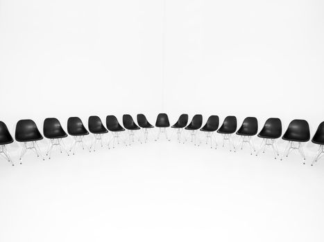 Black chairs in a row isolated on white background